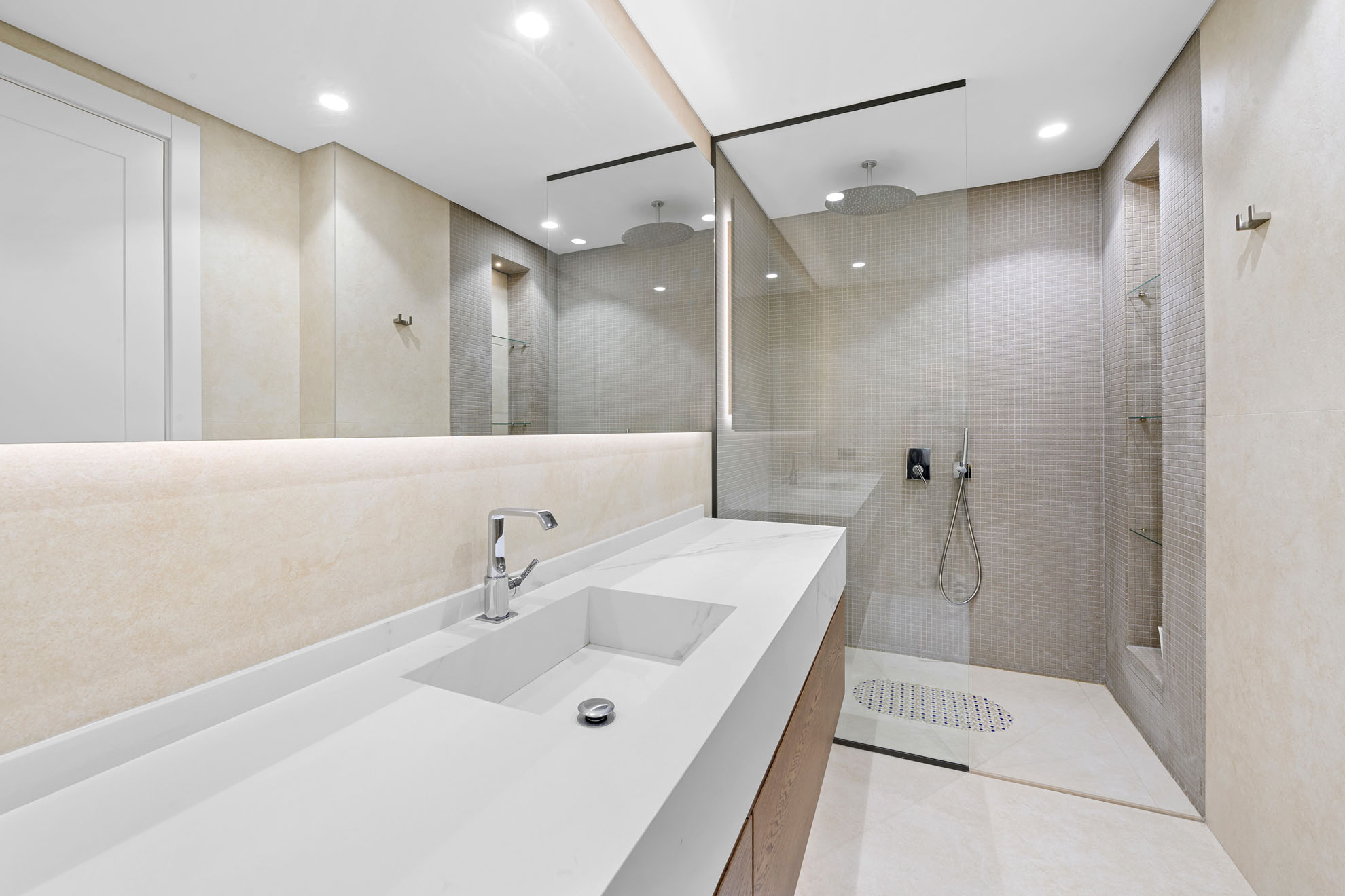 İzmir Urla'da yer alan lüks villanın cam duşakabinli ve ahşap detaylı modern banyo tasarımını gösteren emlak fotoğrafı.