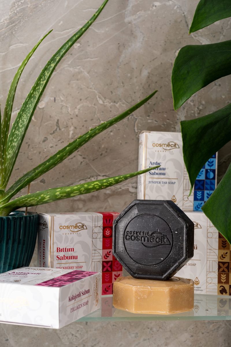 Mecitefendi konsept çekiminde cam rafta sekizgen doğal sabunlar, kutuları ve aloe vera yaprakları.