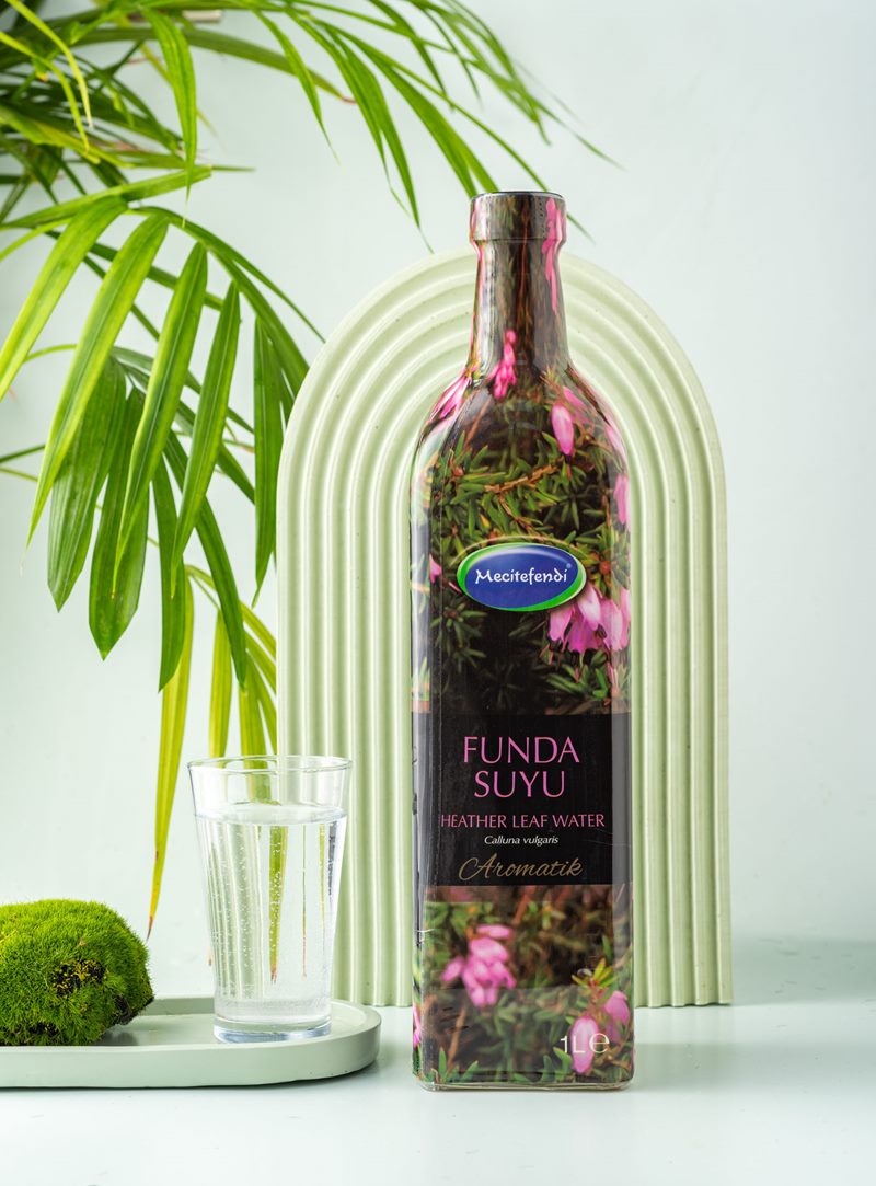 Mecitefendi konsept stüdyo çekiminde yeşil kemer önünde aromatik doğal funda suyu ve su bardağı.