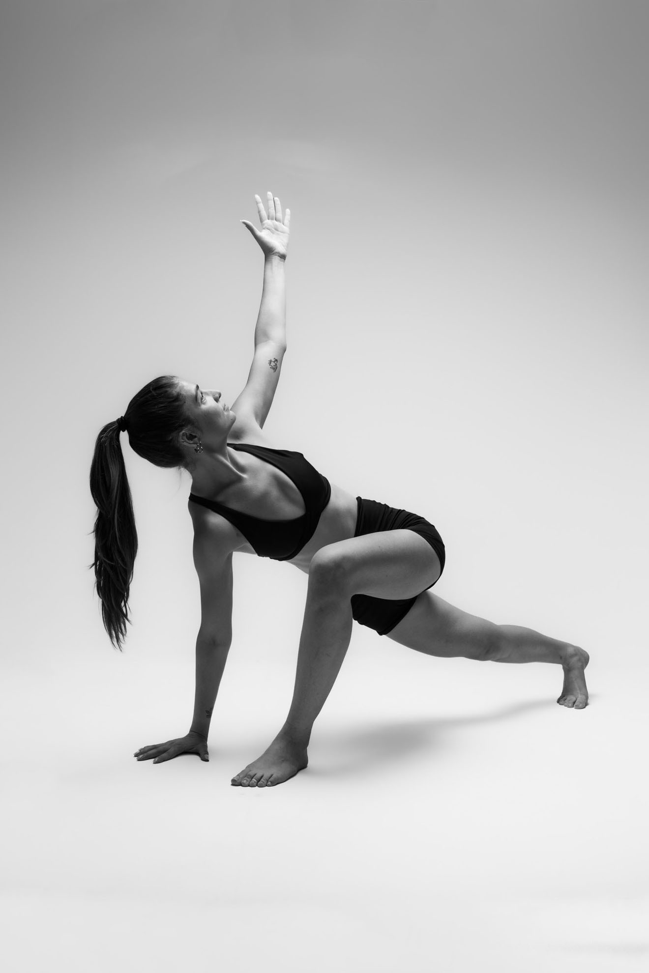 İzmir Menemen'deki minimalist stüdyoda estetik bir siyah beyaz yoga asana pozu veren yoga eğitmeni yogawithmelis.