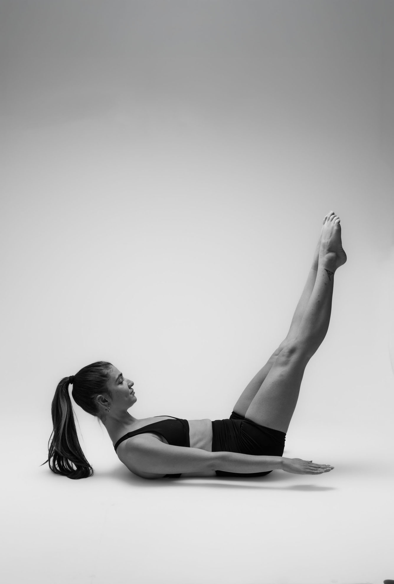İzmir'deki minimalist stüdyoda estetik bir yoga asana pozu veren yogawithmelis, siyah beyaz fotoğrafta dinginliği yansıtıyor.