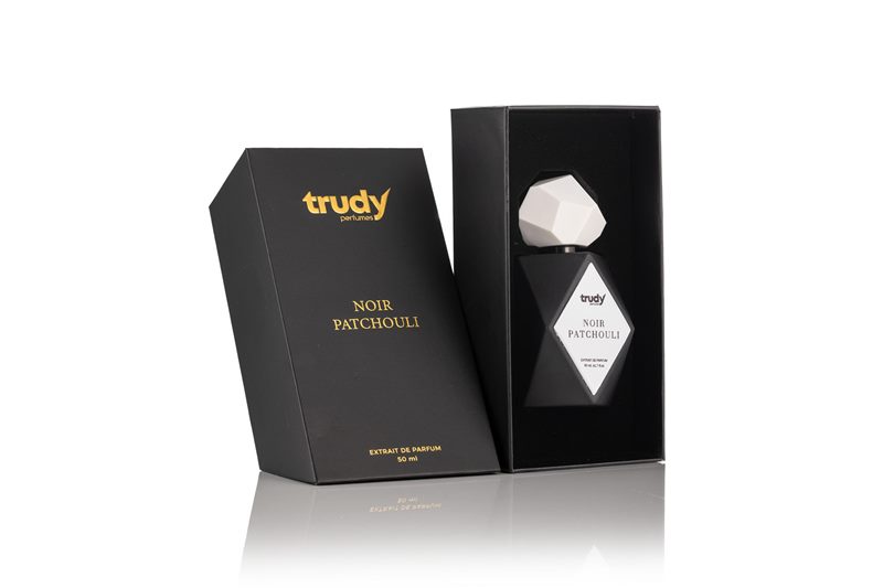 Mat siyah kutusu ve beyaz geometrik kapaklı şişesiyle Trudy Noir Patchouli modelinin beyaz fonda parfüm ürün fotoğrafı.