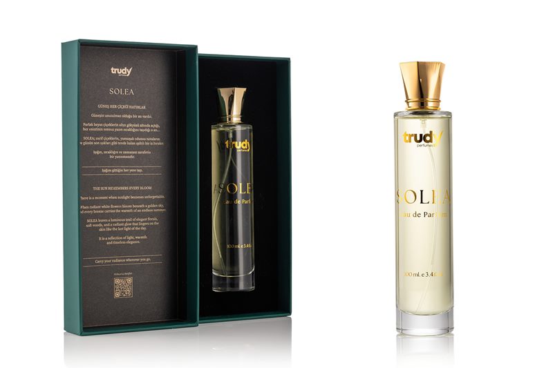 Koyu yeşil hediye kutusu ve silindirik cam şişesiyle Trudy Solea modelinin beyaz fonda çekilen parfüm ürün fotoğrafı.