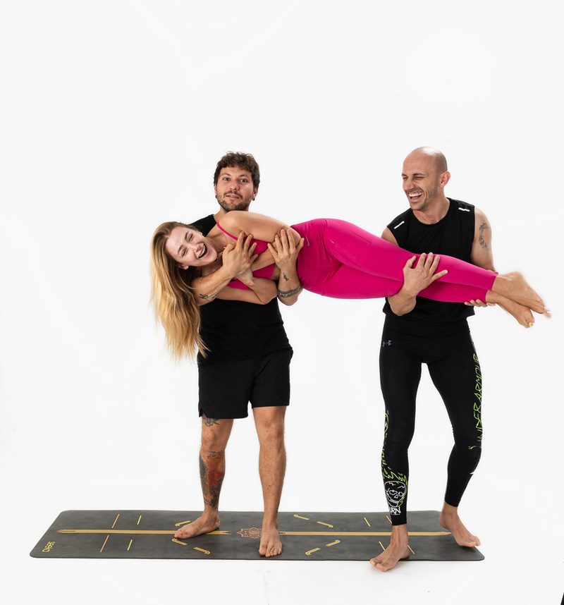 İzmir stüdyo ortamında iki erkek eğitmenin kadın eğitmeni havada taşıdığı neşeli Kentli Gurular yoga fotoğraf çekimi.