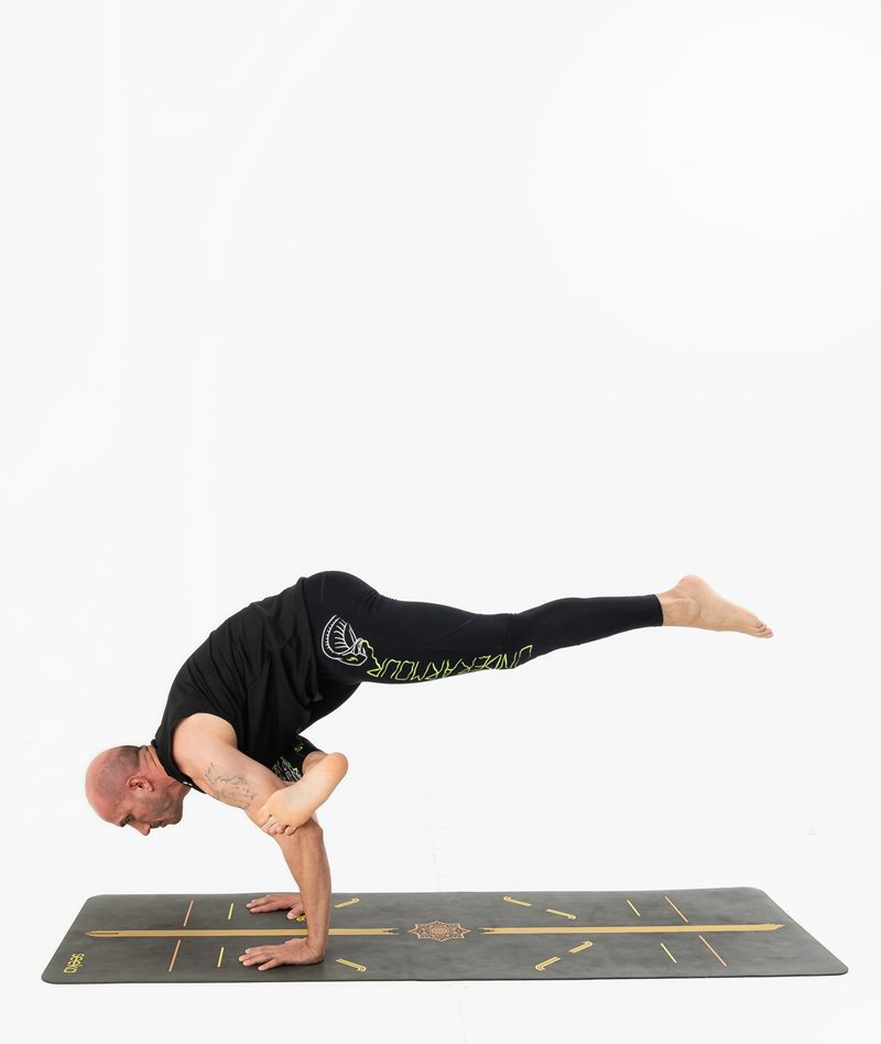 İzmir stüdyoda erkek yoga eğitmeninin kolları üzerinde gövdesini yere paralel taşıdığı kol dengesi, Kentli Gurular yoga fotoğraf çekimi.