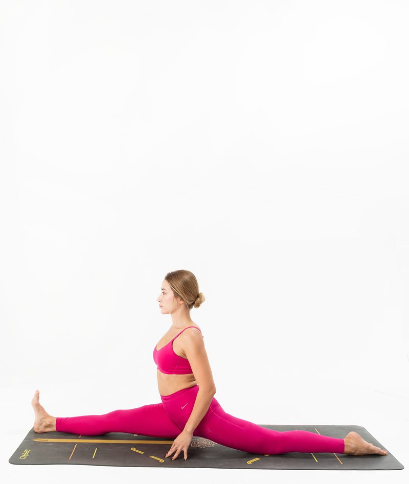 İzmir stüdyo zemininde kadın yoga eğitmeninin tam bacak açma duruşu sergilediği Kentli Gurular yoga fotoğraf çekimi.