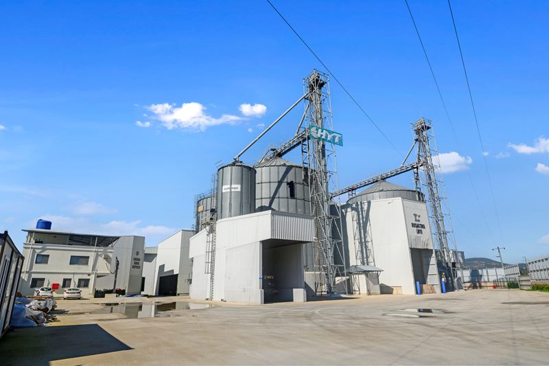 Antrepo tesisinde çelik silo grubu, elevatör kuleleri ve idari yapılar, açık havada HDR tekniğiyle çekilmiş kare.