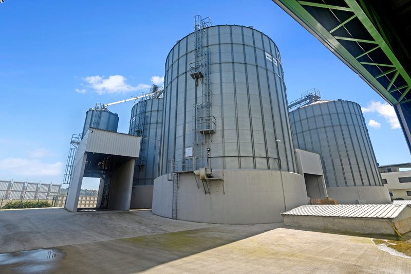Geniş açıyla büyük çelik silonun gövdesi, merdiveni ve yanındaki silo grubu, HYT Lojistik antrepo sahası.