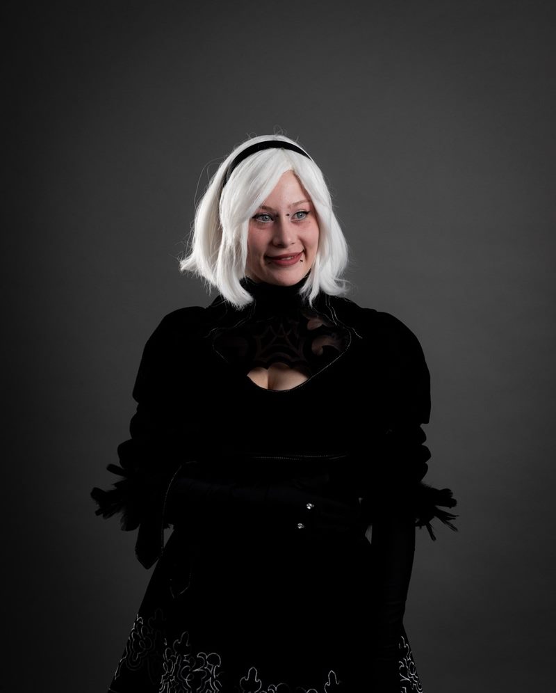 İzmir cosplay fotoğraf çekimi kapsamında gri stüdyo fonunda beyaz peruklu ve siyah elbiseli 2B karakter portresi.