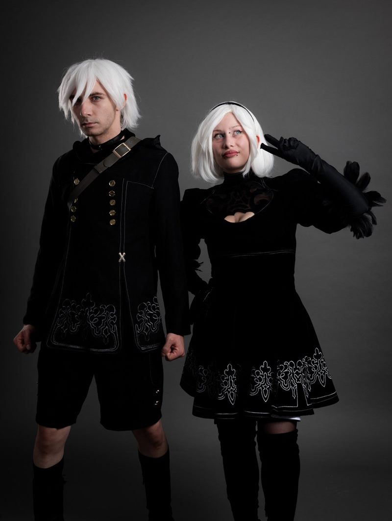 İzmir cosplay fotoğraf çekimi sırasında gri stüdyo fonunda yan yana poz veren NieR Automata 2B ve 9S karakterleri.